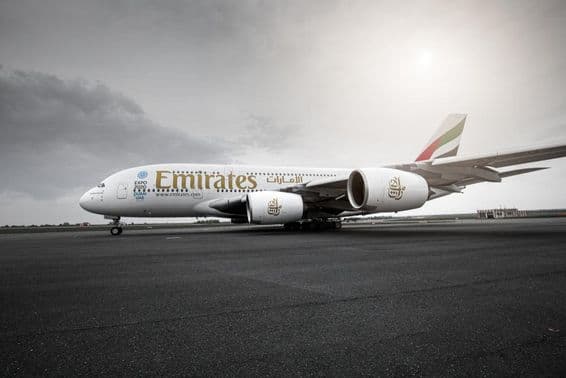 Самолет Emirates, стоящий на взлетно-посадочной полосе.