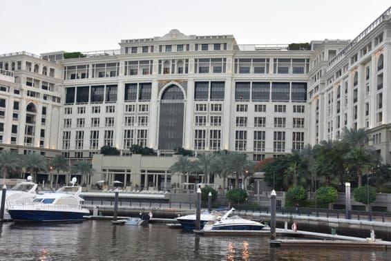 Отель Palazzo Versace в Дубае, с моторными лодками, покачивающимися на воде поблизости.