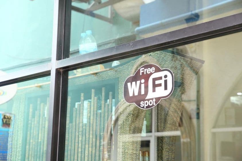 Вывеска в окне кафе с рекламой бесплатного WiFi.