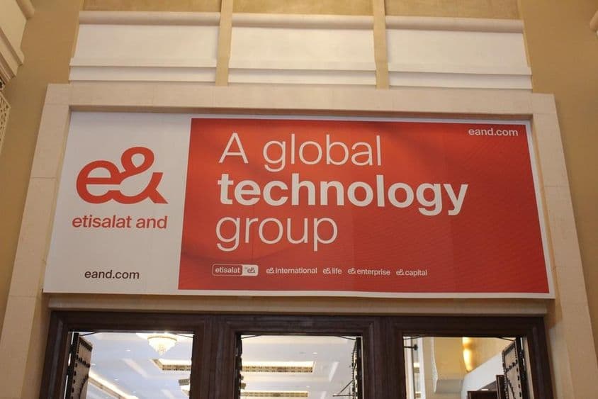 Реклама компании Etisalat над витриной с видимым стеклянным входом.