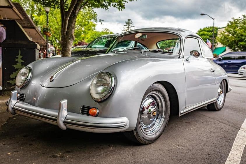 Porsche 356A стоит припаркованный под деревом.