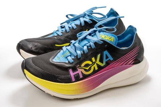 Спортивная обувь Hoka с красочным узором, преимущественно черная, с белой подошвой.