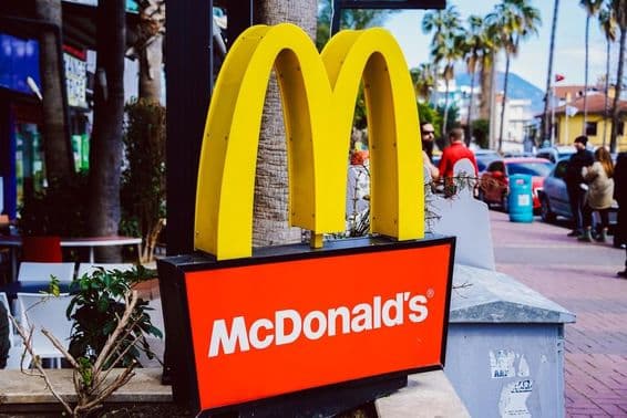 Знак McDonald's на фоне уличного вида.