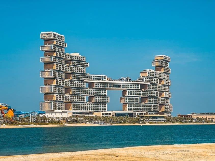 Отель Atlantis The Royal на заднем плане с водой и пляжем на переднем.