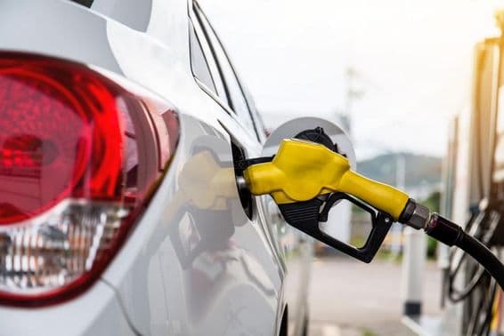 Топливный пистолет вставлен в горловину бака автомобиля.