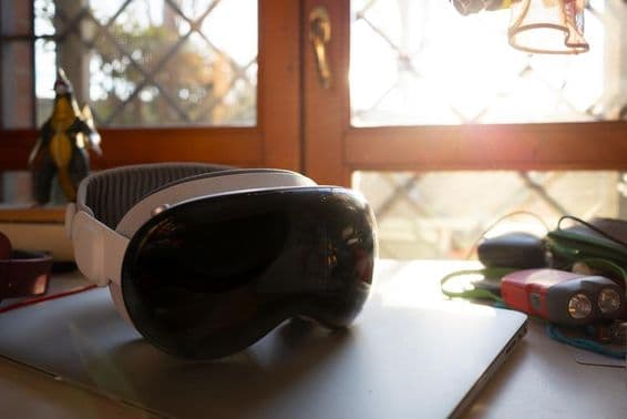 Apple Vision Pro лежит на тетради на столе.