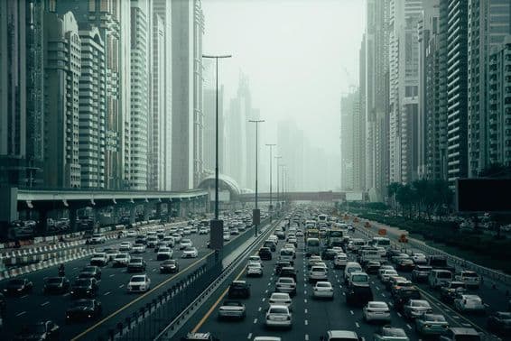 Загруженная автомагистраль Дубая в городе, 2x7 полос, небоскребы по обеим сторонам.