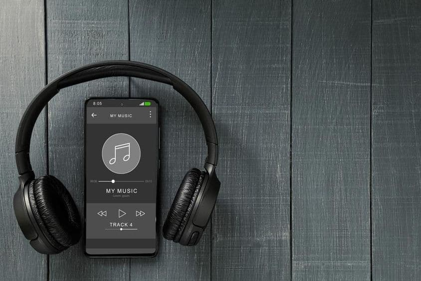 Воспроизведение музыки на телефоне, рядом с наушниками.