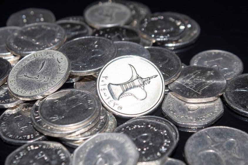 Кучка разбросанных монет номиналом 1 дирхам.
