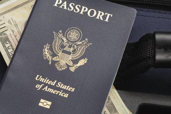 Паспорт США, лежащий на долларах.