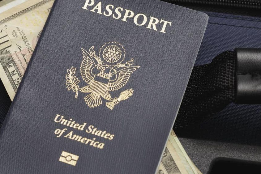 Паспорт США, лежащий на долларах.