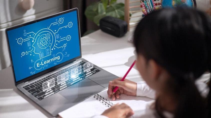 Школьница изучает учебный материал дома.