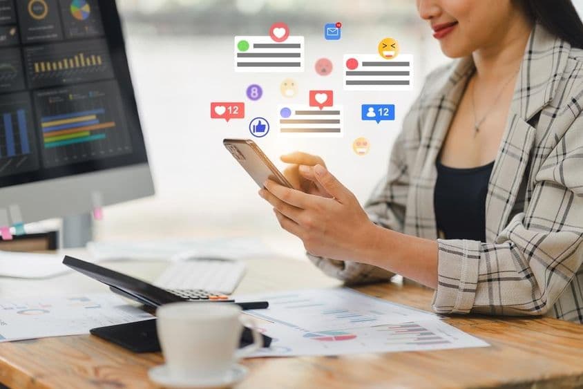 Молодая женщина ведет переписку на телефоне.