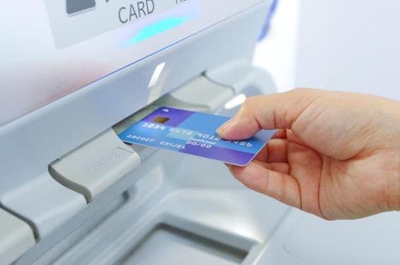 Снятие наличных в банкомате с помощью банковской карты.