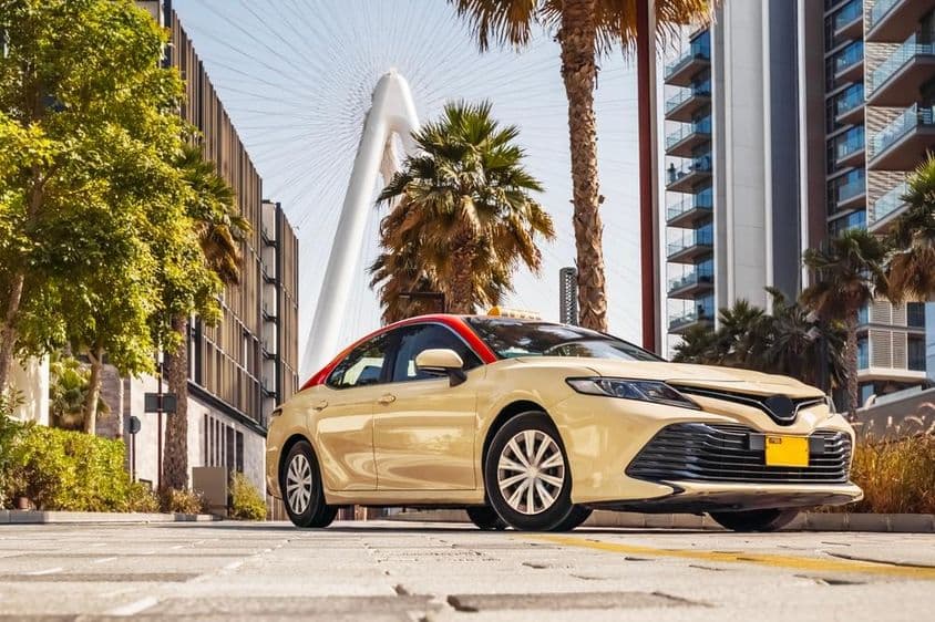 Транспортное средство такси в Дубае на фоне колеса обозрения.