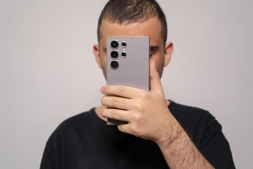 Человек держит смартфон Samsung S24 Ultra, подчёркивая элегантный дизайн.