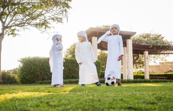 Группа детей с Ближнего Востока, играющих и весело проводящих время на улице.