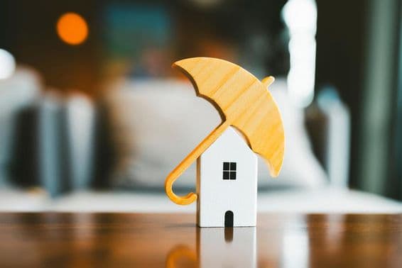 Модель зонтика на деревянном домике, страхование жилья.