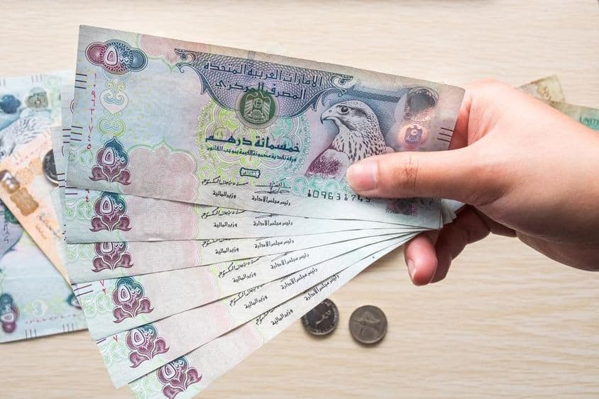 Девушка держит банкноты 500 дирхамов ОАЭ, бумажные деньги.