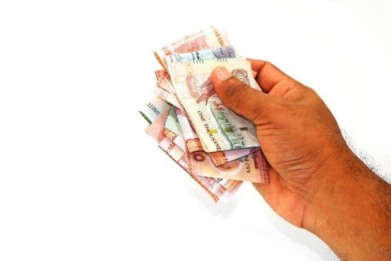 Банкноты дирхам в руке мужчины.