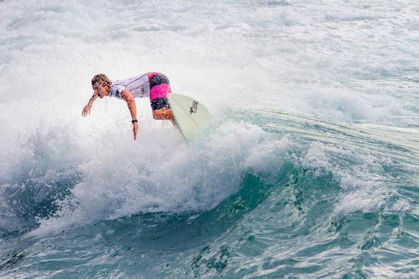 Молодой парень катается на большой волне.