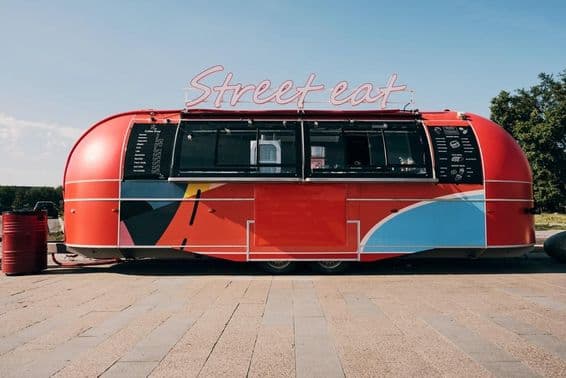 Красный фудтрак, продажа быстрого питания в середине улицы или площади.