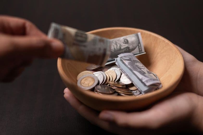 Пожертвование, собираемое в деревянной посуде.