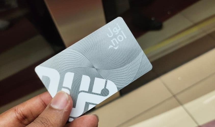 Путешественник в Дубае держит карту Nol для метро.