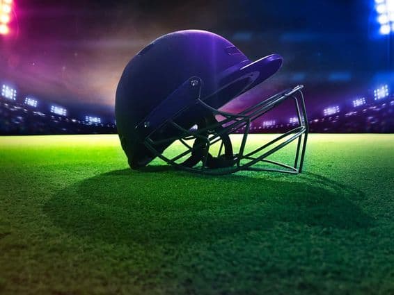 Крикетный шлем снизу на зелёной траве.