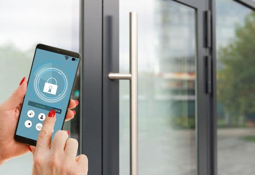 Смартфон с приложением умного дома на экране.