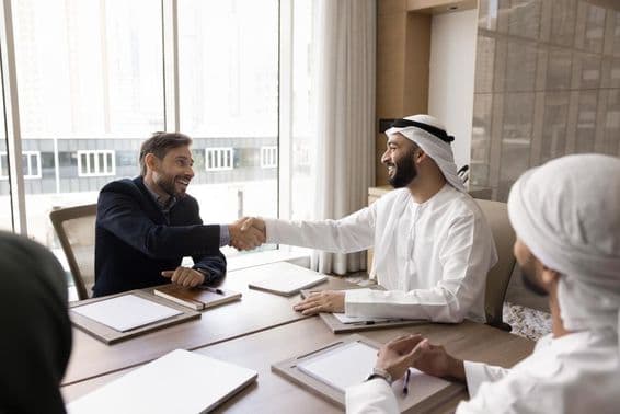 Международные бизнес-партнеры заключают успешные переговоры рукопожатием.