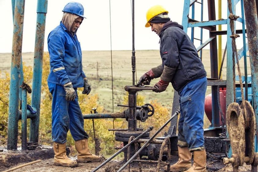 Рабочие осматривают нефтяной насос.