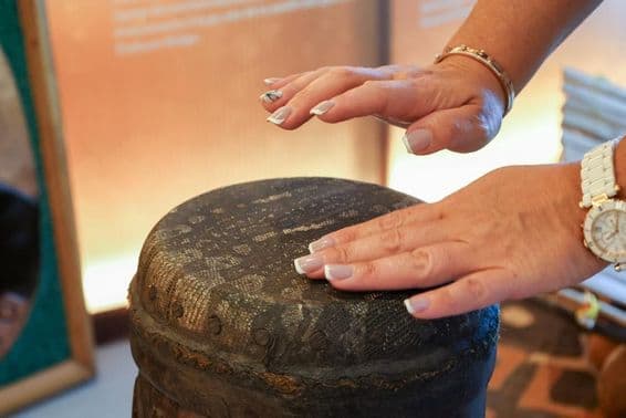 Дубай, Объединенные Арабские Эмираты, женщина африканского происхождения играет на перкуссионном барабане.