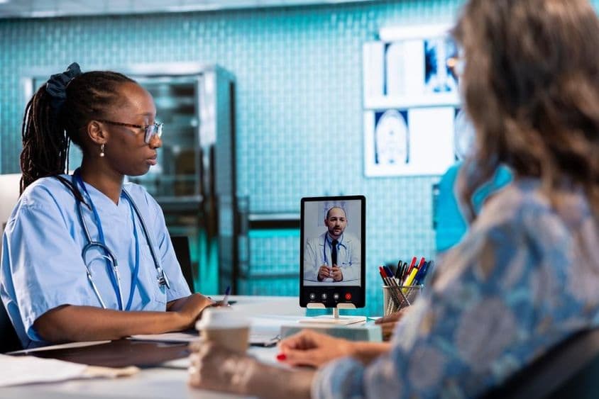 Медсестра, ведущая видеоразговор с врачом для удаленной консультации и телемедицины.