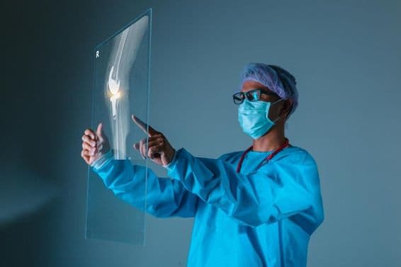 Врач держит рентгеновский снимок кости пациента перед операцией.