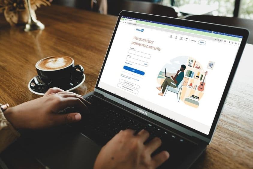 Человек открывает страницу входа в LinkedIn на MacBook.
