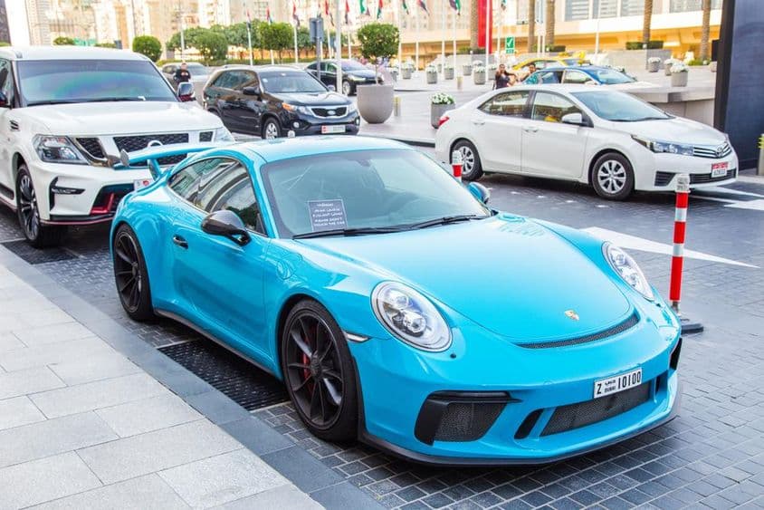 Дубай, синий Porsche на парковке.