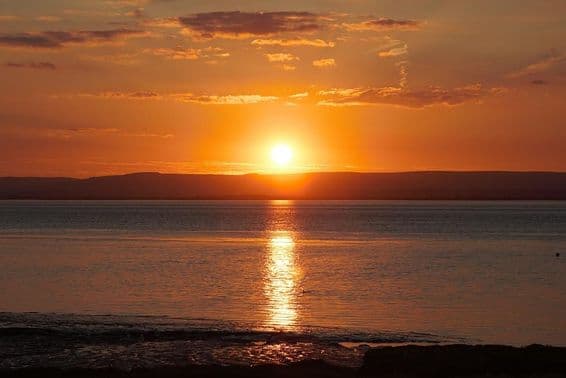 Закат, отражённый в воде и облаках во время летнего солнцестояния.