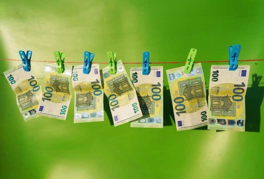 100 евро купюры, сушащиеся на бельевой веревке.