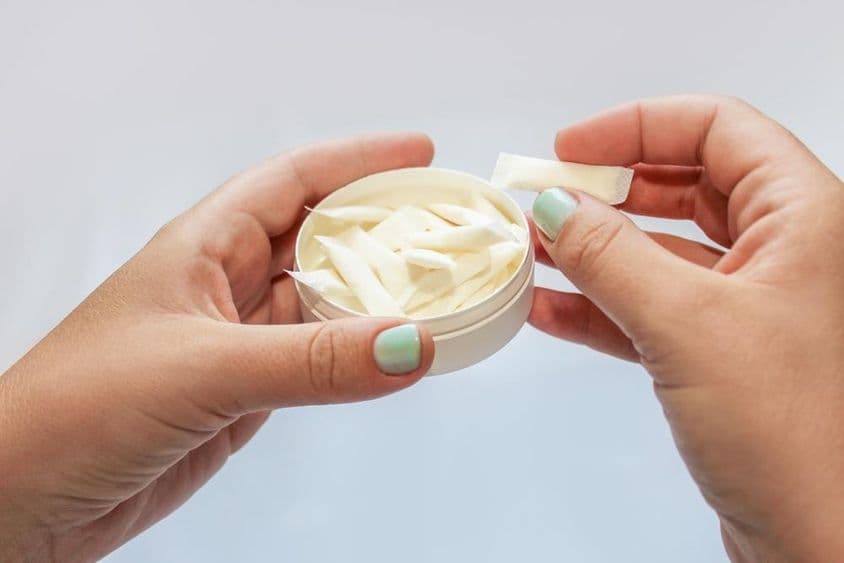 Пакеты снус, никотиновые пластыри в руках.