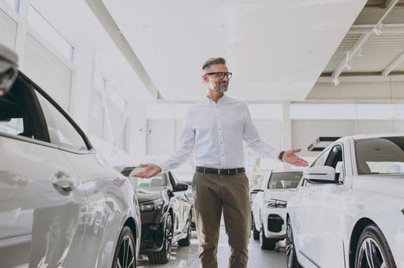 Уверенный состоятельный взрослый мужчина с покупками в классической рубашке.