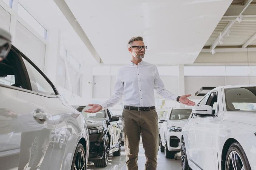 Уверенный состоятельный взрослый мужчина с покупками в классической рубашке.