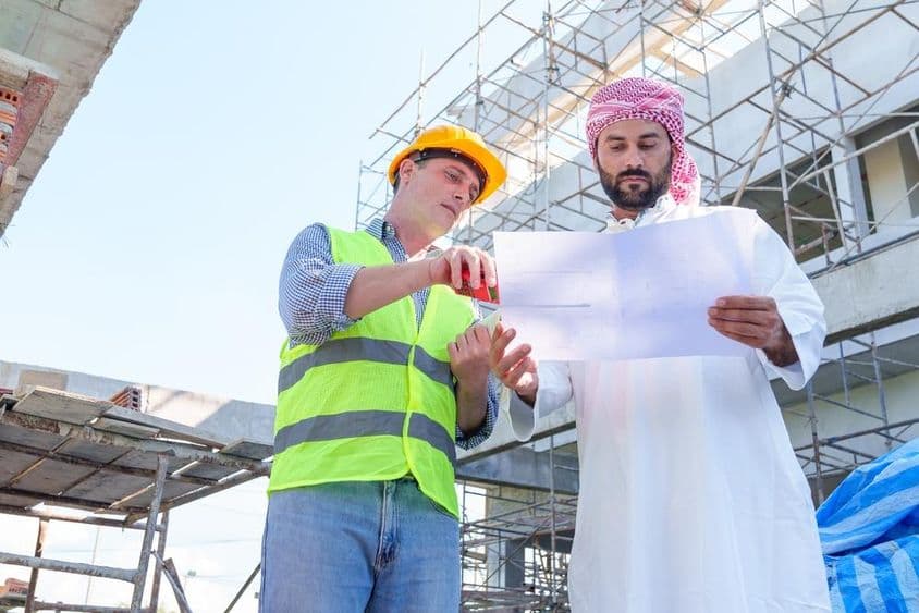 Арабский бизнесмен изучает чертеж гражданского строительства.