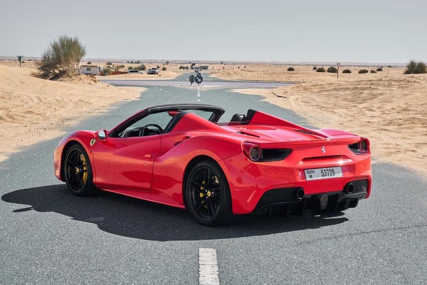Красный Ferrari 488 на заброшенной дороге в пустыне Дубая.