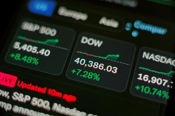 Рост акций, отображаемый на экране в виде зеленых графиков.