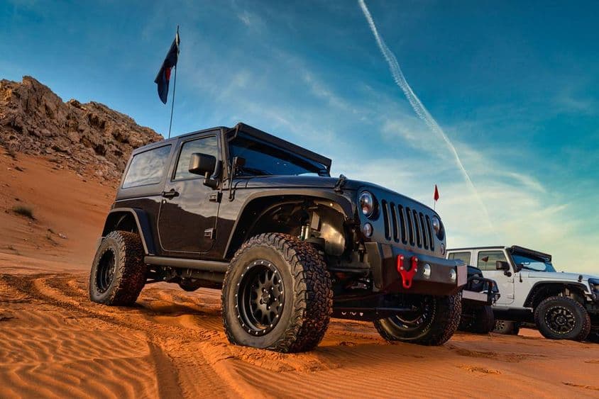 Jeep Wrangler на внедорожном приключении на песчаной дюне в красной пустыне Дубая.