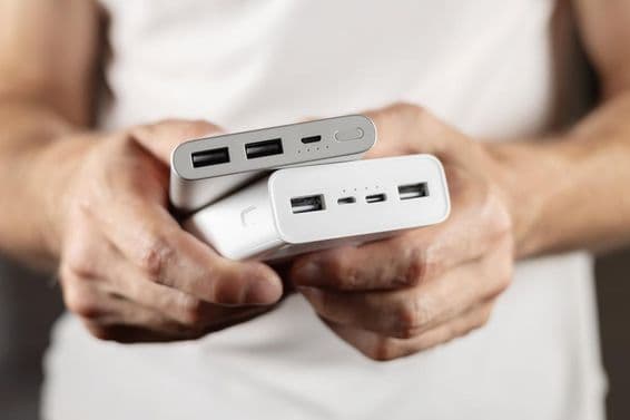 Два внешних аккумулятора в руках.