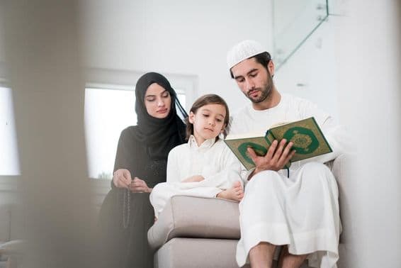 Молодые родители и маленький мальчик читают книгу.