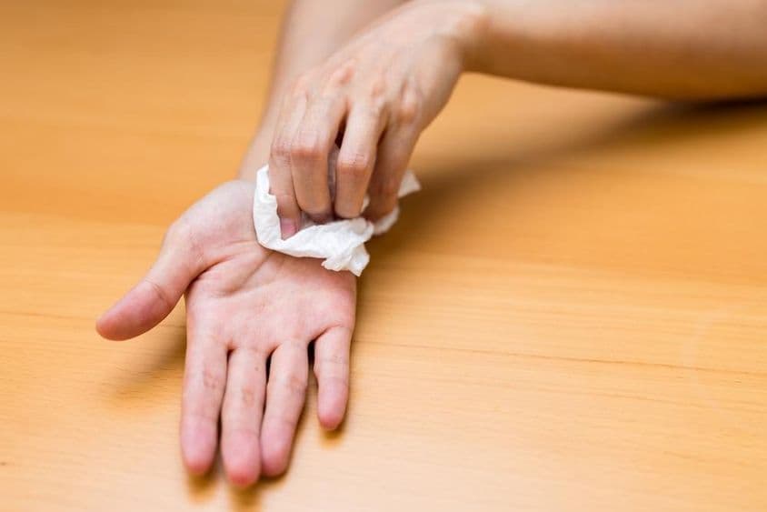 Женщина страдает от потных рук.