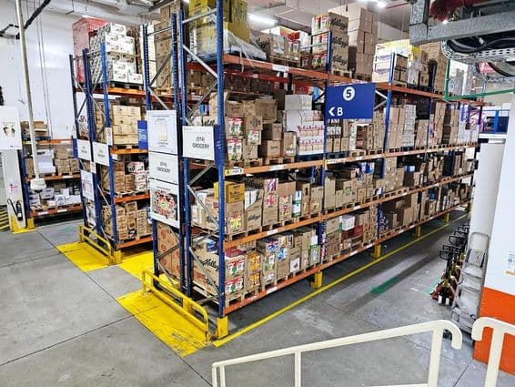 Склад с системами стеллажей, маркировкой категорий продуктов и знаками безопасности, обеспечивающими гладкую работу.